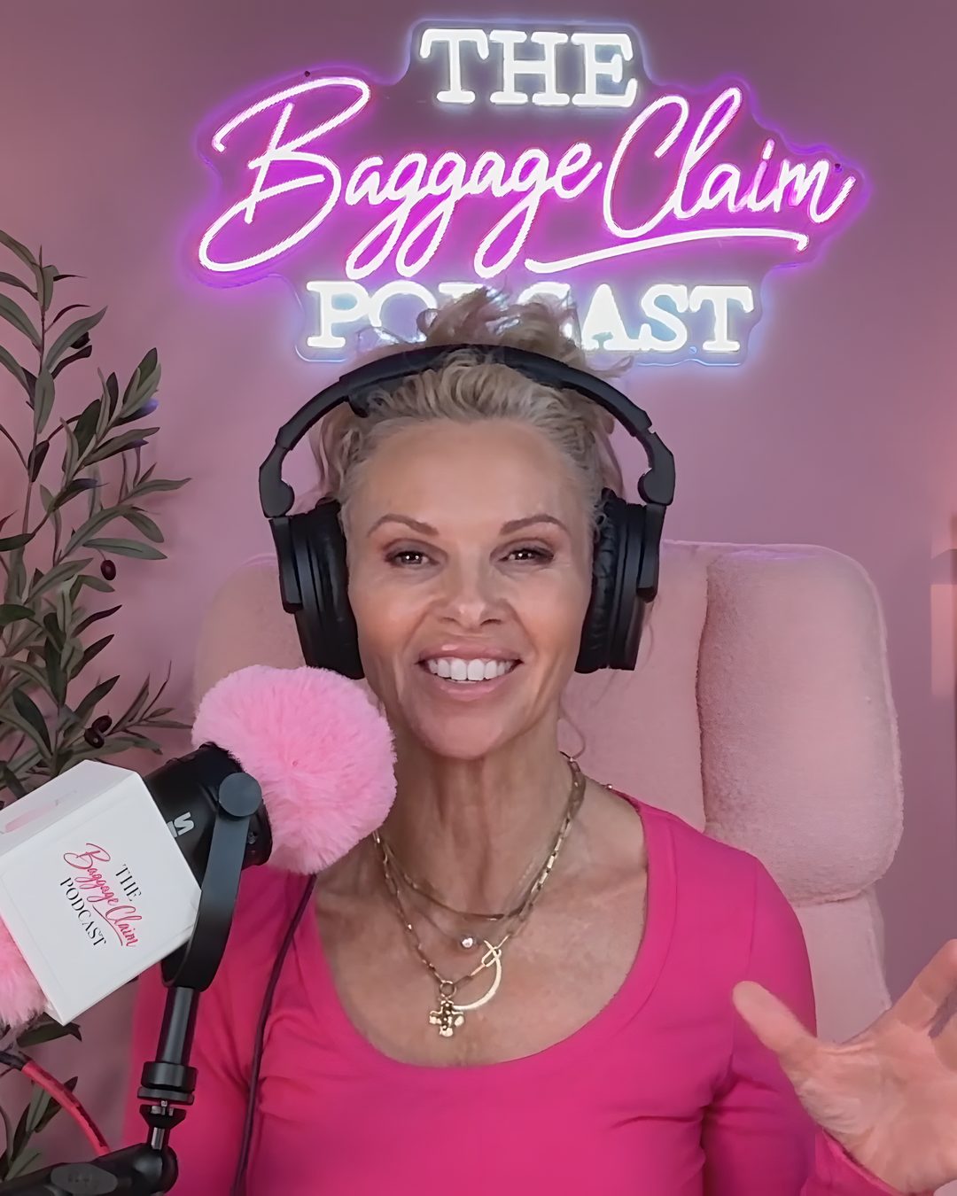 Lisa Najarian smiling at the microphone under The Baggage Claim neon sign